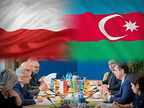 Flagi Polski i Azerbejdżanu poniżej przedstawiciele NIK i gości delegacji azerbejdżańskiej w trakcie rozmów przy stole