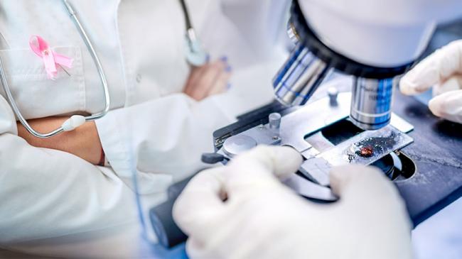 Kolaż zdjęć: Lekarka z różową wstążeczką w klapie fartucha obok próbka badana pod mikroskopem